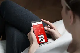 Person mit Smartphone in der Hand, die die Austrian App benutzt.