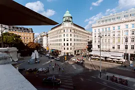 Vista esterna del centro informazioni turistiche di Albertinaplatz, carrozza trainata da cavalli e pedoni in primo piano